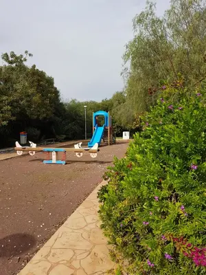 a playground with a blue slide in a park at Holiday Apartment with Sea View (0002913) in Paralimni