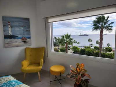 a bedroom with a window with a view of the ocean at Luxury Kalipso Beachfront in Limassol