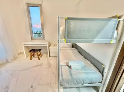 two bunk beds in a room with a table at Sol e Mar Villa 2 in Paralimni
