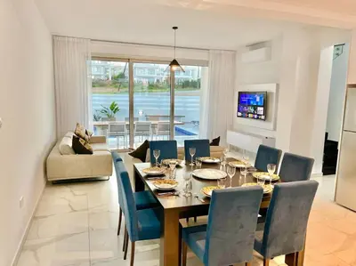 a dining room with a table and blue chairs at Sol e Mar Villa 2 in Paralimni
