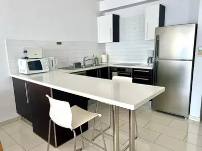 a kitchen with a white counter and a refrigerator at Eden Dream Apartments in Limassol