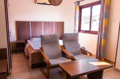 a bedroom with a bed and a table and chairs at Lakis Court in Larnaka