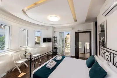 a bedroom with a large bed and a table and chairs at Accomoteleia Crystal Lagoon Villa in Protaras
