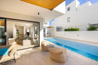 a house with a swimming pool and a living room at Protaras Periyiali Seaside Villa 33 in Protaras