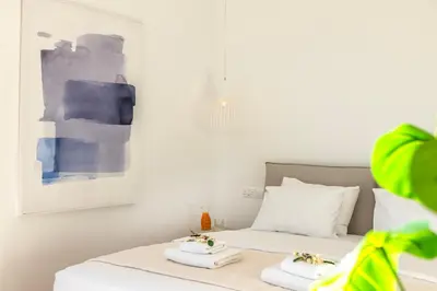 a bedroom with two beds with towels and a painting at Protaras Periyiali Seaside Villa 33 in Protaras