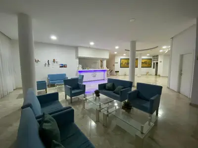 a living room with blue couches and a purple fireplace at Boronia Hotel Apartments in Larnaka