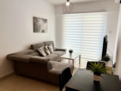 a living room with a couch and a tv at Mackenzie 11 in Larnaka