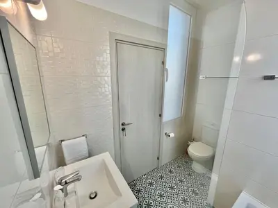a white bathroom with a sink and a toilet at Alasia Villa ll Kapparis in Paralimni