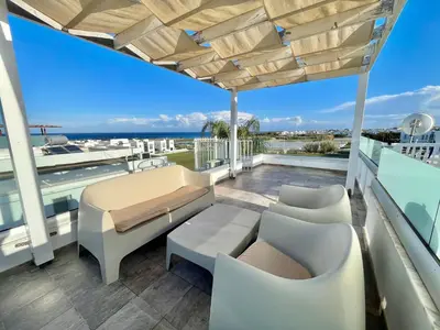 a patio with a couch and chairs on a balcony at Alasia Villa ll Kapparis in Paralimni