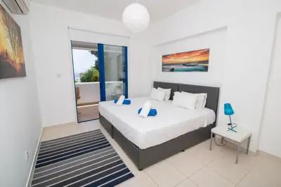 a bedroom with a bed and a large window at The Good Times Apartment in Protaras