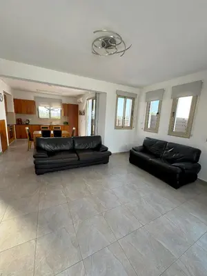 a living room with two black leather couches at Villa TaMalDi side sea view - new renovated! in Paralimni