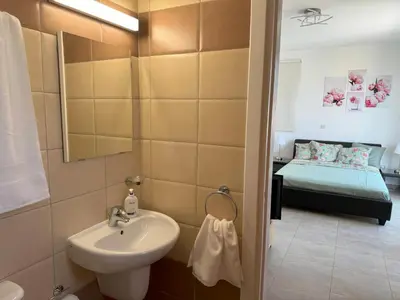a bathroom with a sink and a bed in a room at Villa TaMalDi side sea view - new renovated! in Paralimni