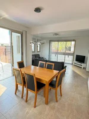 a dining room with a wooden table and chairs at Villa TaMalDi side sea view - new renovated! in Paralimni
