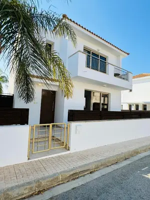a white house with a balcony on a street at Villa TaMalDi side sea view - new renovated! in Paralimni