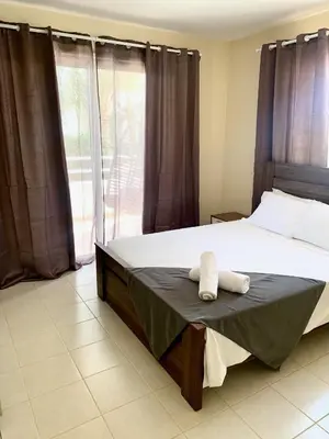 a bedroom with a bed with two towels on it at Nissi 3 E8 Pool View Apt in Ayia Napa