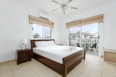 a bedroom with a large bed and a balcony at Spacious Villa with Private Pool & Breathtaking Panoramic Ayia Napa views in Ayia Napa