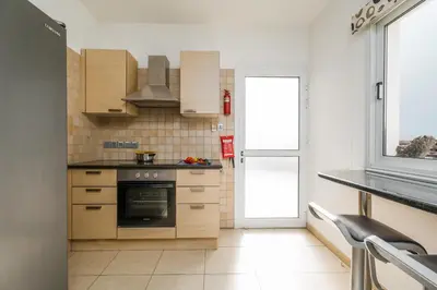 a kitchen with wooden cabinets and a stove at Spacious Villa with Private Pool & Breathtaking Panoramic Ayia Napa views in Ayia Napa