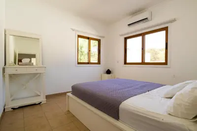 a white bedroom with a bed and a mirror at Captivating 2-Bed House in Alaminos