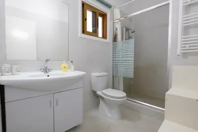a white bathroom with a toilet and a sink at Captivating 2-Bed House in Alaminos