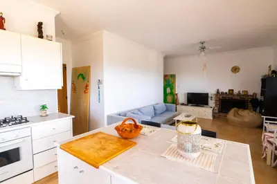 a kitchen with white cabinets and a table in a room at Captivating 2-Bed House in Alaminos
