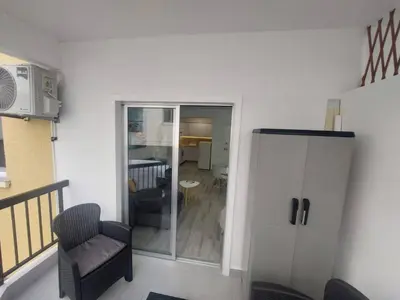 a living room with a chair and a sliding glass door at AMAZING TWO BEDROOM APARTMENT in Ayia Napa
