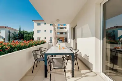 a table and chairs on the balcony of a apartment at Cozy 2 Bedroom Family Apartment w/ Pool in Protaras
