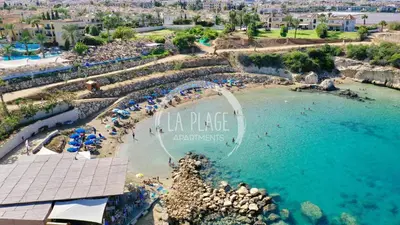 an aerial view of a beach with people in the water at Cozy 2 Bedroom Family Apartment w/ Pool in Protaras