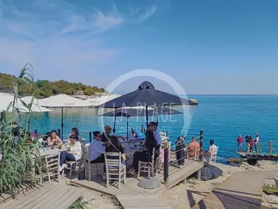 a group of people sitting at a table by the ocean at Cozy 2 Bedroom Family Apartment w/ Pool in Protaras