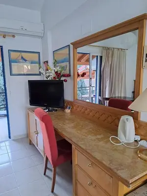 a room with a desk with a mirror and a television at GALATEX BEACH STUDIO in Limassol