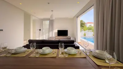 a living room with a table with glasses and a couch at City Napa Seaview Villas - Villa 4 in Ayia Napa