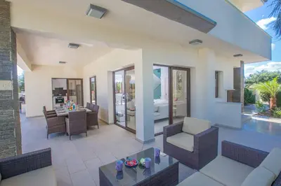 a living room with chairs and a table in a house at Protaras Demetra Villa DE1 in Protaras