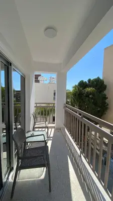 a balcony with chairs and a view of the ocean at T&L Apartments Agiaos Tychonas in Limassol