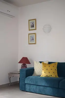 a blue couch in a living room with a table at T&L Apartments Agiaos Tychonas in Limassol