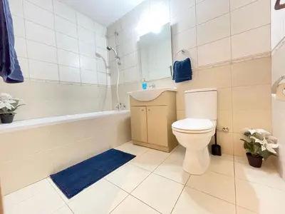 a bathroom with a toilet and a bath tub at Sunset Pearl Holiday Apt. - Ayia Napa in Ayia Napa