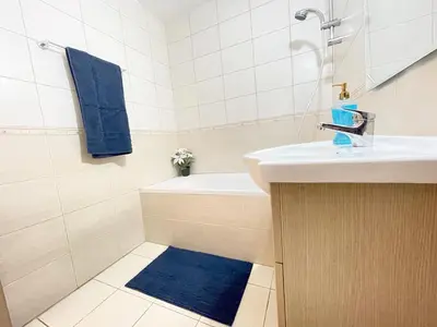 a bathroom with a sink and a blue rug at Sunset Pearl Holiday Apt. - Ayia Napa in Ayia Napa