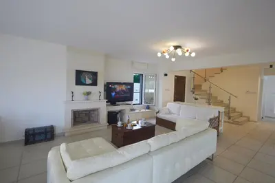 a living room with a white couch and a tv at Serifos Villa 7 - 100 meters from Malama Beach in Protaras