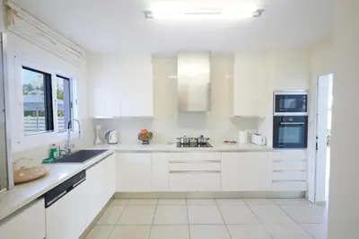 a white kitchen with white cabinets and a window at Serifos Villa 7 - 100 meters from Malama Beach in Protaras
