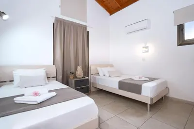 two beds in a room with white walls at Villa Anthia - 2bed with Large Pool in Ayia Napa