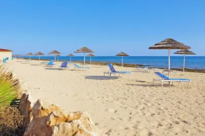 a group of chairs and umbrellas on a beach at Villa Anthia - 2bed with Large Pool in Ayia Napa