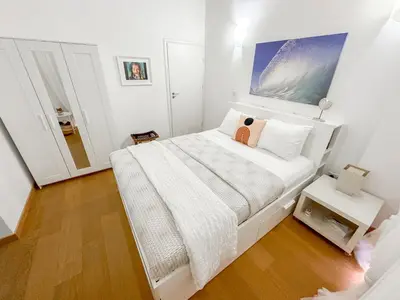 a white bedroom with a bed and a mirror at Villa Olivo Maroni in Maroni