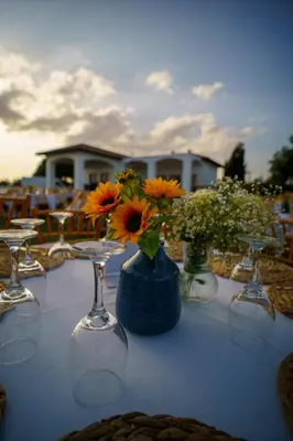 a table with a blue vase with flowers in it at Villa Olivo Maroni in Maroni