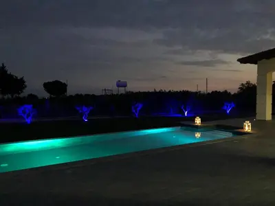 a swimming pool lit up at night with blue lights at Villa Olivo Maroni in Maroni
