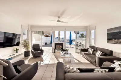 a living room with two couches and a fireplace at Faros Seaside Villa Larnaca in Pervolia
