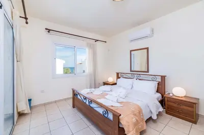 a bedroom with a large bed and a window at Villa Malamar in Protaras