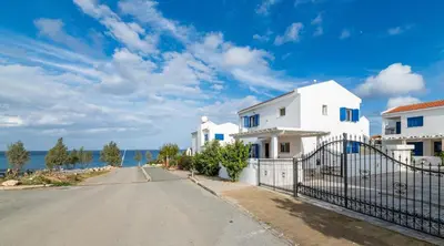 an empty street in front of a house with the ocean at Villa Malamar in Protaras