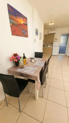 a dining room table with chairs and a painting on the wall at Duplex Apartment in Larnaka