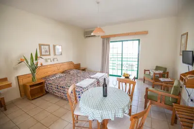 a bedroom with a bed and a table with a dining room at Eligonia Hotel Apartments in Ayia Napa