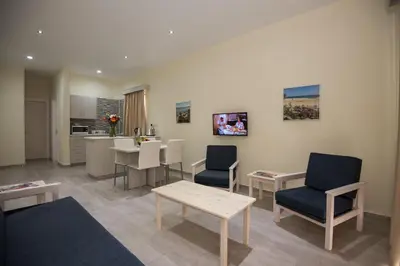 a living room with a table and chairs and a kitchen at Eligonia Hotel Apartments in Ayia Napa