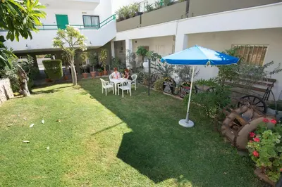 a couple sitting at a table under an umbrella at Eligonia Hotel Apartments in Ayia Napa