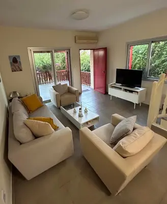 a living room with two white couches and a television at Beautiful maisonette in Protaras in Protaras